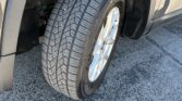 Close-up of a car's front-right wheel and tire, showing the tread and exposed suspension inside the wheel well.