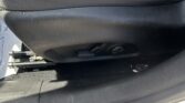 Car seat bottom with visible metal track and adjustment lever underneath leather upholstery.
