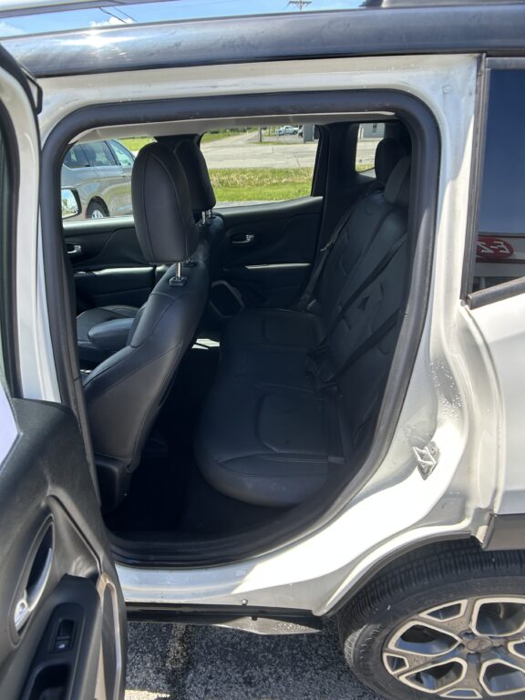 Rear passenger seating in a gray SUV with black leather seats, door open
