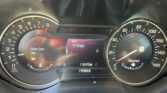 Car dashboard with tachometer on left, speedometer on right, central warning says 'Driver Door Ajar' and odometer at 115470 miles.