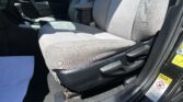 Interior of a car's front cabin showing gray cloth seats, center console with an armrest, and the gear shifter to the left of the passenger seat.