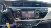 Center-dash view: dual air vents, small digital clock between vents, and a touchscreen infotainment system below.