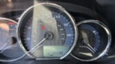 Close-up of a car's instrument cluster: speedometer up to 140 mph and odometer reading 130,590 miles with a red warning light visible on the dashboard.