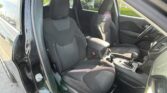 Interior view of a dark-colored SUV showing the front driver and passenger seats, center console, and a visible open door on the left edge of the frame.