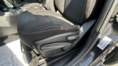 Front passenger-seat area of a car interior with center console, gear shift lever, and seat belt buckle visible in daylight.