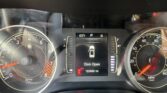 Close-up of the vehicle instrument cluster: tachometer left, speedometer right, and center screen showing 'Door Open' with 63°F and gear 'P' indicators.