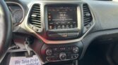 In-car infotainment screen showing FM radio set to 96.9 Classic Rock in a parking lot view outside the windshield.