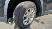 Close-up of a Goodyear tire on a chrome alloy wheel on a black pickup, with a dirt-splattered fender nearby.