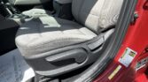 Front seat interior of a red car with gray fabric seats, center console, and gear shifter visible by the door.