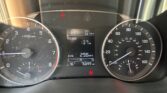 Car dashboard showing red seatbelt warning, tachometer on left, speedometer on right, and central digital readout with PRND, range 137 mi, avg 29.8 MPG, 76°F, and 76,899 miles.