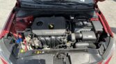 Open hood shows the engine bay of a red car, with a black plastic engine cover labeled DOHC 16V, battery, and various hoses and cables visible.