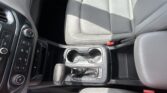 Interior of a car showing gray leather seats, center console with cup holders and gear shifter