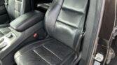 Black leather car seats with white contrast stitching in a clean SUV interior, front row visible from open door