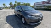 Gray minivan in a parking lot near an EZ Loan storefront on a sunny day.