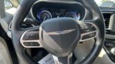 Interior view of a car steering wheel with the Chrysler emblem and dashboard gauges visible