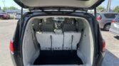 SUV with the rear hatch open, showing folded third-row seats and an empty cargo area