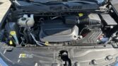 Open car hood exposing the engine bay with the air intake, coolant reservoir, and battery visible.