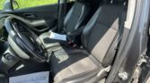 Inside a car cabin showing the driver and front passenger seats with papers resting on the passenger seat.