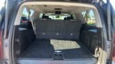 Open rear hatch of a Chevrolet SUV showing a spacious cargo area with folded second-row seats and a ceiling-mounted entertainment screen visible inside the cabin