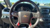 Close-up of a Chevrolet steering wheel inside a car, with the instrument cluster and infotainment screen visible