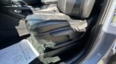 Front passenger seat and center console in a car with black leather upholstery and stitched seams