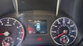 Close-up of a car dashboard: speedometer on the right, tachometer on left, central display shows fuel level, gear in Park, and 120,297 miles.