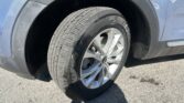 Close-up of a blue SUV wheel and tire, showing tread and silver alloy rim