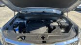 Car with hood open, showing the engine bay from the front in a parking lot