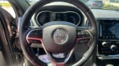 Jeep steering wheel viewed from the driver’s seat with the dashboard and touchscreen nearby.