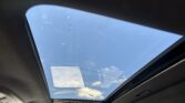 Open sunroof in a car revealing blue sky and wispy clouds