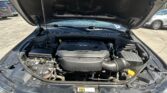 Open car hood revealing engine bay with V6 engine cover visible