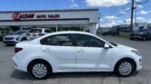 White sedan in the foreground at an E-Z Loan Auto Sales storefront on a sunny day.