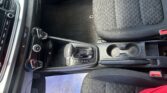 Front passenger area of a car interior with a patterned seat, gear shifter, center console, and a white sheet of paper on the floor beneath the seat.