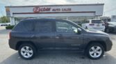 Black SUV in foreground at an auto dealership with the E-Z LOAN AUTO SALES sign on the building signage visible above.
