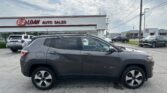 Front view of a dark SUV parked in a car lot in front of EZ LOAN AUTO SALES building.