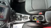 Inside a car showing the center console with gear shifter, climate controls, and leather seats.