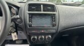 Inside view of a car dashboard with dual air vents, touchscreen display, and climate controls, plus a paper sign in the foreground reading 'We Take Pride In Your Vehicle!'