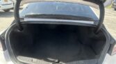 Open trunk of a sedan showing empty black cargo space and rear window view