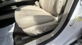 Beige leather car driver seat with power-adjustment controls on the lower side and part of the door frame visible.