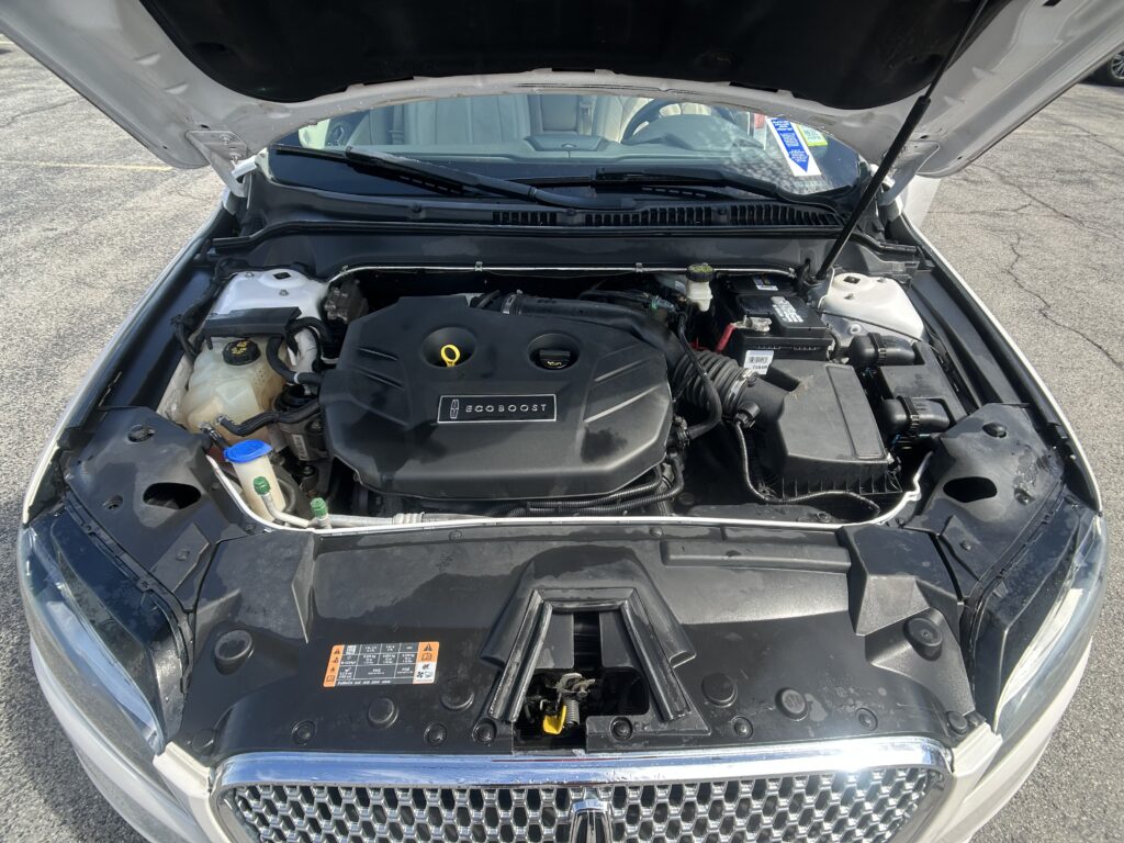 Open hood reveals engine bay with EcoBoost engine cover visible in center