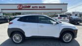 White SUV parked in front of EZ LOAN Auto Sales storefront on a sunny day.