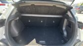 Open hatchback trunk with a raised privacy cover in a parking lot outside.