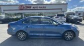 Blue sedan parked in front of E-Z Loan Auto Sales storefront on a sunny day, with other cars in the lot behind it.