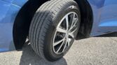 Close-up of a car tire and alloy wheel mounted on a blue vehicle