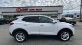 White SUV in foreground at an EZ LOAN Auto Sales lot with a white building and other cars in the background under a cloudy sky.