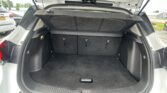 Open SUV trunk showing folded rear seats and cargo area with dark carpeting