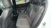 Rear passenger seats in a car with black upholstery, visible seat belts and headrests.