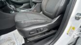 Driver's seat and center console of a car interior, with the gear shifter and armrest visible.
