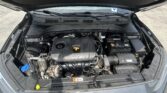 Open car hood revealing the engine bay with battery on the right, air intake, and engine cover labeled DOHC 16V.