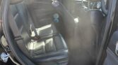 Interior view of a black leather SUV with sun glare and rainbow lens flares across the cabin.